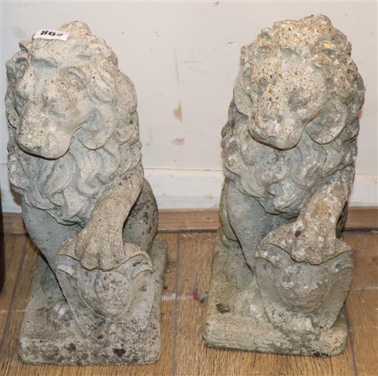 A pair of reconstituted stone lion garden ornaments H.36cm